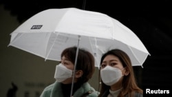 Passengers wearing masks to prevent contacting the coronavirus walk outside Seoul Railway Station in Seoul, South Korea, February 25, 2020. REUTERS/Kim Hong-Ji