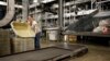 FILE - A UPS employee works inside the company's Worldport hub in Louisville, Ky. 