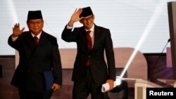 Capres No. 02 Prabowo Subianto (kiri) bersama Cawapres Sandiaga Uno melambai kepada hadirin sebelum acara Debat Capres perdana, Kamis malam (17/1).