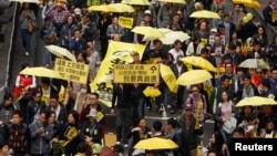 Protesters carrying yellow umbrellas, the symbol of the Occupy movement, march on a street in Hong Kong, Feb. 1, 2015. 