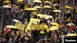 Para demonstran membawa payung kuning, simbol gerakan Occupy, berbaris di jalanan di Hong Kong (1/2). (Reuters/Liau Chung-ren)