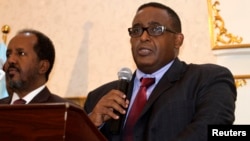 FILE - Newly elected Somalia Prime Minister Omar Abdirashid Ali Sharmarke, right, flanked by Somalia's President Hassan Sheikh Mohamud, addresses delegates in Mogadishu, Dec. 17, 2014. 