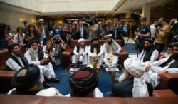 Mullah Abdul Ghani Baradar, the Taliban group's top political leader, left, Sher Mohammad Abbas Stanikzai, the Taliban's chief negotiator, second left, and other members of the Taliban delegation speak to reporters prior to their talks in Russia.