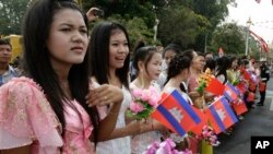 Women hold Cambodian and Chinese flags for welcoming Chinese President Hu Jintao in front of the Royal Palace in Phnom Penh, Cambodia, March 31, 2012.