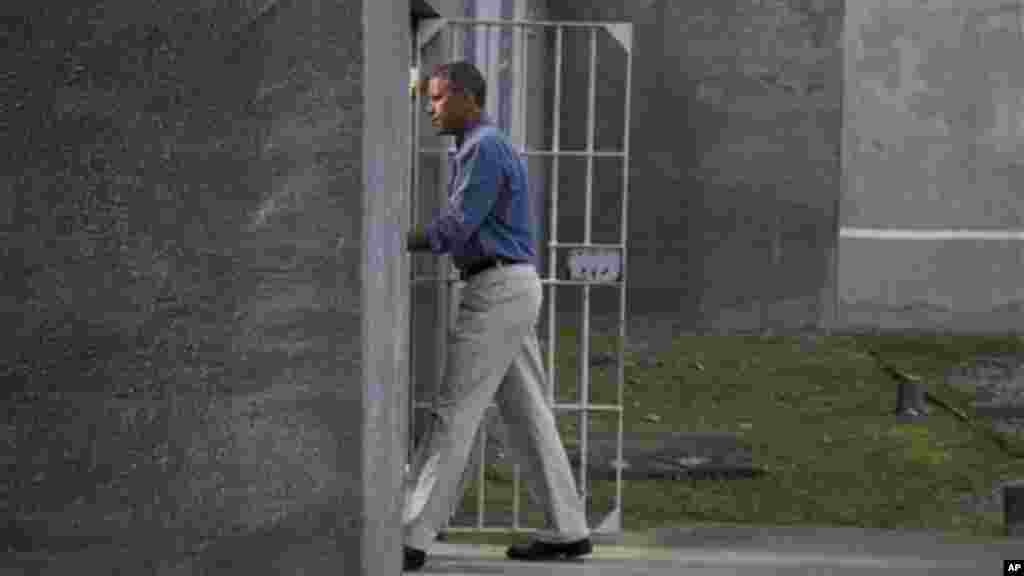 President Obama walks into a cell block during a tour of Robben Island.