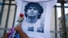 Un homme place une fleur sur un maillot avec le visage de la star du football Diego Maradona lors d'une marche pour exiger des réponses concernant sa mort, à Buenos Aires, Argentine, le 10 mars 2021.
