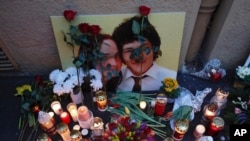 Candles sit in front of a photo of journalist Jan Kuciak and his fiancee during a rally to mark one year anniversary of the slayings of Kuciak and his fiancee, in Bratislava, Slovakia, Feb. 21, 2019. 