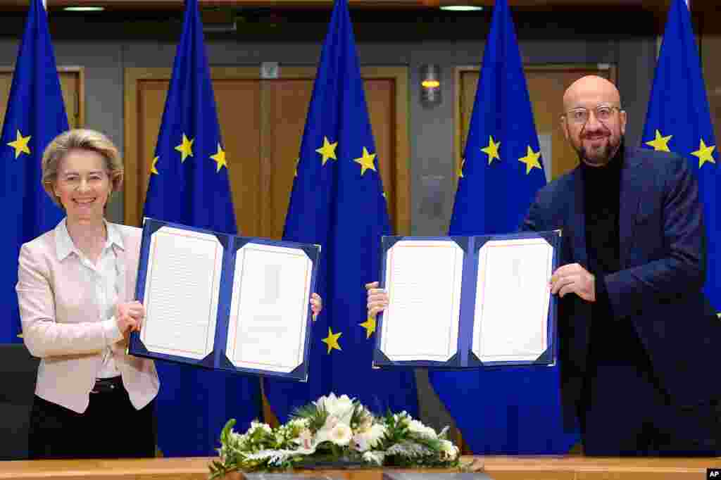 European Commission President Ursula von der Leyen, left, and European Council President Charles Michel show signed EU-UK Trade and Cooperation Agreements at the European Council headquarters in Brussels, Belgium.