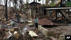 Dua orang warga membawa material dari bangunan yang hancur pasca bentrokan antar Muslim Rohingya dan pemeluk agama Budha, Rakhine di Sittwe, ibukota negara bagian Rakhine, Burma (Foto: dok). Kelompok HAM menyerukan tindakan untuk mengakhiri kekerasan di wilayah ini.