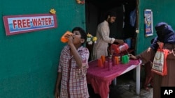 File - A volunteer distributes drinking water next to a bus stand on a hot day in Hyderabad, India, March 21, 2024. Earth just had its warmest March ever recorded, the 10th month in a row to set such a record, according to the European Union climate agency Copernicus. 