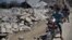 Syrians look at a destroyed house after it was hit by an air strike killing six Syrians in town of Tal Rifat on the outskirts of Aleppo, Syria, Aug. 8, 2012. 