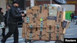 A delivery person pushes a cart full of Amazon boxes in New York City, U.S., Feb. 14, 2019.