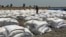 Bags of food dropped by air from a World Food Program plane are sorted in Padeah, South Sudan. South Sudanese who fled famine and fighting in Leer county emerged from South Sudan's swamps after months in hiding to receive food aid.