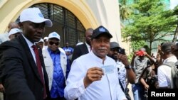 FILE —Denis Kadima, president of Democratic Republic of Congo's Independent National Electoral Commission, shows his electoral card after his registration process during the launch of voter registration for the December 2023 general election, in Kinshasa, December 24, 2022.