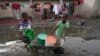 Des enfants vont chercher de l'eau à l'aide d'une brouette dans le township de Lilanda à Lusaka, en Zambie, le samedi 9 mars 2024. (AP Photo/Tsvangirayi Mukwazhi)