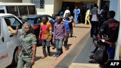 Des policiers encadrent un homme arrêté, suspecté dans la crise anglophone, ici dans la cour d’un tribunal à Yaoundé, Cameroun, 14 décembre 2018.