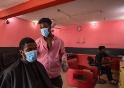 Kofi, a barber, resumes work after the partial lockdown halt the spread of the COVID-19 was lifted in Accra, Ghana, April 20, 2020.
