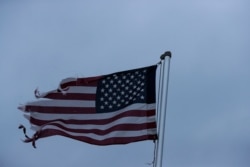 A tattered U.S. flag whips in a heavy wind on April 19, 2020, in Dawson, Ga.