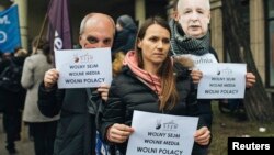 Demonstrators hold banners "Free Parliamnent, Free Media, Free Poles" during a protest in Gdansk, Poland, Dec. 17, 2016. 