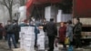 Los residentes se reúnen cerca de un remolque lleno de alimentos y productos de higiene del Comité Internacional de la Cruz Roja en la ciudad controlada por los rebeldes de Donetsk, Ucrania, el 17 de marzo de 2021. Las agencias de la ONU han realizado dos