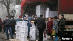 Los residentes se reúnen cerca de un remolque lleno de alimentos y productos de higiene del Comité Internacional de la Cruz Roja en la ciudad controlada por los rebeldes de Donetsk, Ucrania, el 17 de marzo de 2021. Las agencias de la ONU han realizado dos