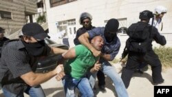 Israeli riot and undercover policemen arrest a Palestinian protester during clashes in the east Jerusalem Arab neighborhood of Issawiya, May 15, 2012.