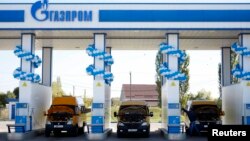 FILE - Vehicles are seen at a gas filling station, owned by Gazprom Transgaz Stavropol, with the company logo of Russian natural gas producer Gazprom seen on the station, in Stavropol in southern Russia.