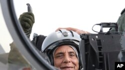 Indian Defense Minister Rajnath Singh thumbs up as he sits in a Rafale jet fighter during an handover ceremony at the Dassault Aviation plant in Merignac, near Bordeaux, southwestern France, Oct. 8, 2019.