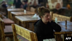 A woman, who fled the breakaway Nagorno-Karabakh region for Armenian territory, reacts in the border town of Goris on Oct. 5, 2020, amid the ongoing fighting between Armenia and Azerbaijan over the disputed region.