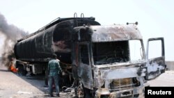 A man inspects an oil tanker truck set ablaze during recent clashes between Yemeni southern separatists and government forces near Aden, Yemen, Aug. 30, 2019.