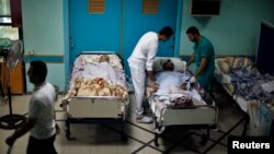 Patients lie in their beds on the ground floor of al-Wafa rehabilitation hospital after being evacuated from the fourth floor, which police said was hit by a tank shell fired by Israeli troops, in Gaza City, July 16, 2014.