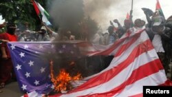 Anggota Front Pembela Islam (FPI) membakar tiruan bendera Amerika dalam unjuk rasa di depan Kedutaan Besar Amerik, di Jakarta, 11 Desember 2017. Para pengunjuk rasa memprotes keputusan Washington untuk mengakui Yerusalem sebagai Ibu Kota Israel