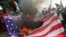 Anggota Front Pembela Islam (FPI) membakar tiruan bendera Amerika dalam unjuk rasa di depan Kedutaan Besar Amerik, di Jakarta, 11 Desember 2017. Para pengunjuk rasa memprotes keputusan Washington untuk mengakui Yerusalem sebagai Ibu Kota Israel