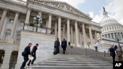 FILE - Members of Congress climb the steps at the Capitol in Washington, July 31, 2014. 