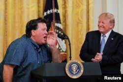 U.S. President Donald Trump applauds Bruce Hrobak, owner of Billy Bones Bait &amp; Tackle, as he expresses his support for the president during an event in the East Room of the White House, July 8, 2019.