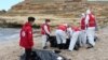 Para petugas Bulan Sabit Merah melakukan evakuasi para korban, pasca tenggelamnya perahu migran di lepas pantai Qassr Alkhyar, Libya.