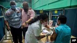 22일 인도 가우하티의 한 실내경기장에서 의료진이 신종 코로나바이러스 백신을 접종하고 있다.