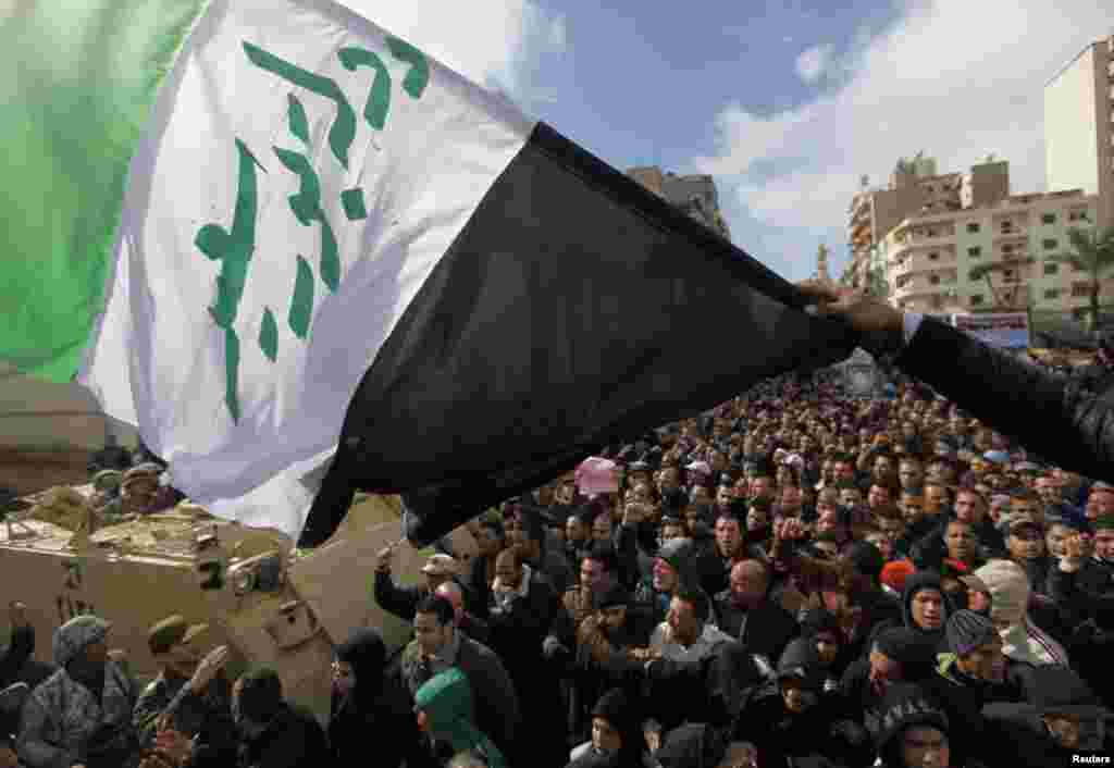 Protesters opposing Egyptian President Mohamed Morsi shout slogans next to a flag with words "Port Said State" written on it, in the city of Port Said Feb. 1, 2013. 