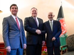 FILE - U.S. Secretary of State Mike Pompeo shakes hands with Afghan President Ashraf Ghani with U.S. Secretary of Defense Mark Esper alongside at the Munich Security Conference in Munich, Germany, Feb. 14, 2020.