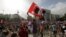 A man waves a flag with a portrait Turkey's founder Kemal Ataturk as thousands of Turkish youths gather at Kizilay Square, Ankara, June 2, 2013.