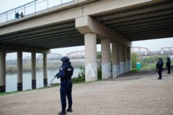 FILE - Mexican federal police officers stand on the bank of the Rio Bravo near a bridge connecting Eagle Pass, Texas, with Piedras Negras, in Piedras Negras, Mexico, Feb. 10, 2019.