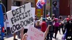 Protesters demonstrate against stay-at-home orders that were put in place due to the COVID-19 pandemic, in Huntington Beach, California, April 17, 2020. 