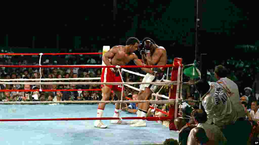 Le champion du monde George Foreman conduit son challenger Muhammad Ali dans les cordes avec un jab de gauche au corps pendant le combat de championnat WBA / WBC à Kinshasa, au Zaïre, le 30 Octobre, 1974. Ali a repris la couronne des poids lourds en assommant Foreman au cours du huitième round de leur combat surnommé &laquo;Rumble in the Jungle&raquo;. (AP Photo) 