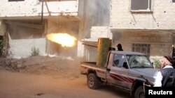 A rebel fighter fires during clashes with Syrian forces in eastern al-Ghouta, near Damascus, April 8, 2014. 