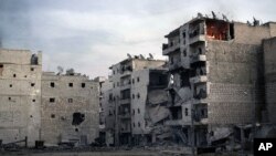 A fire is seen inside an apartment (R) of a damaged building due to heavy fighting between Free Syrian Army fighters and government forces in Aleppo, Syria, December 5, 2012.