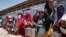 FILE - In this photo taken Feb. 25, 2017, displaced Somali girls who fled the drought in southern Somalia stand in a queue to receive food handouts at a feeding center in a camp in Mogadishu, Somalia.