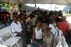 Patients wait under a tarp to see a doctor from the U.S. Navy hospital ship USNS Comfort anchored off Port-au-Prince, Haiti, Nov. 8, 2019.