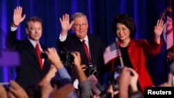 De izquierda a derecha los senadores Rand Paul de Kentucky, Mitch McConnell y su esposa celebran la victoria en Louisville, Kentucky.