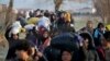 Migrants walk to reach Pazarakule border gate, Edirne, Turkey, at the Turkish-Greek border on Sunday, March 1, 2020. 