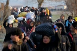 Migrants walk to reach Pazarakule border gate, Edirne, Turkey, at the Turkish-Greek border, March 1, 2020.